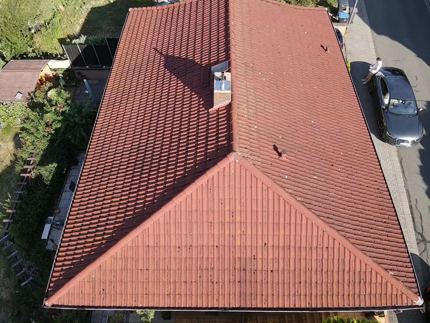 Dach eines Hauses mit roten Ziegeln und Schornstein, Miat Solartech GmbH