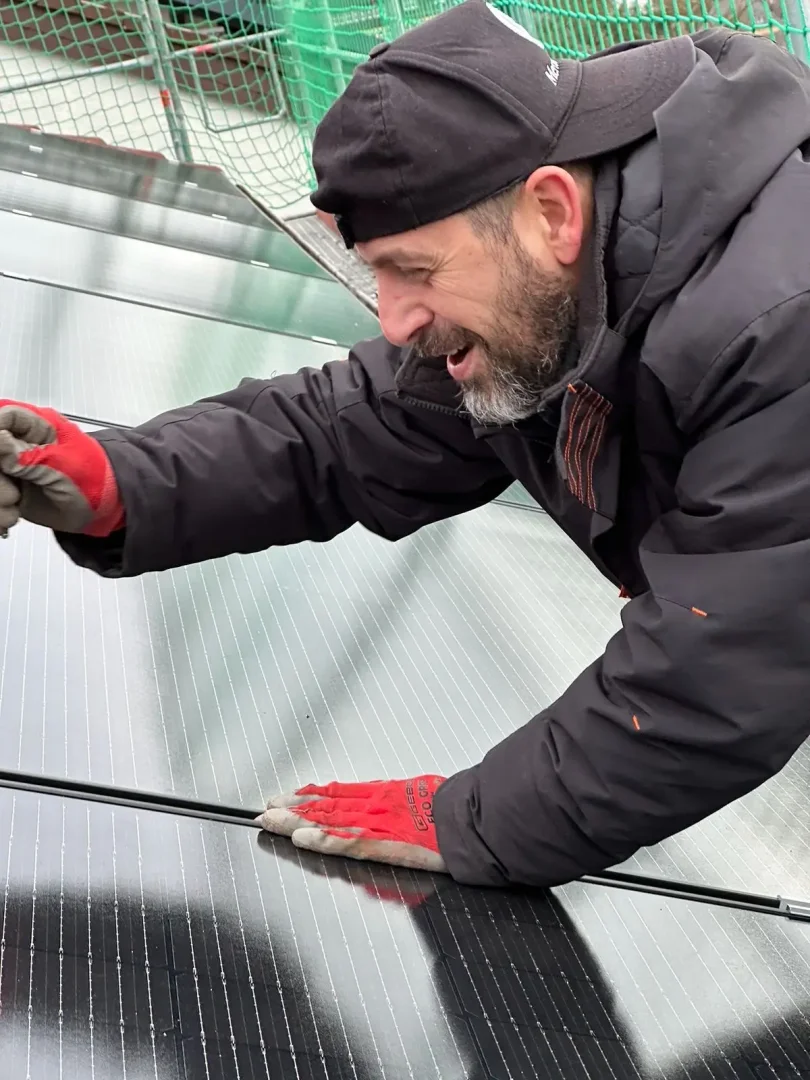 Mann installiert Solarpanel auf Dach