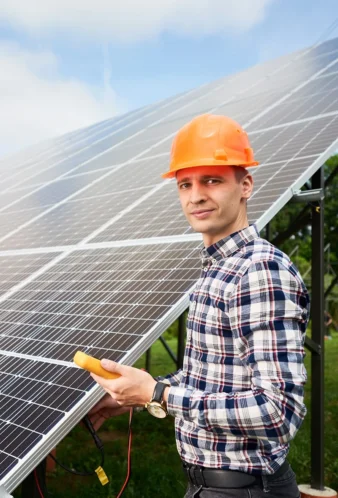 Mann mit Helm überprüft Solarpanel