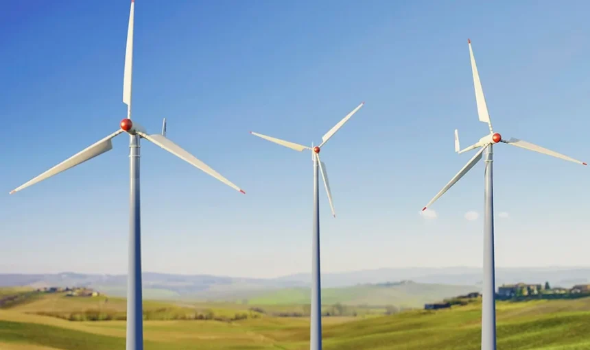 Drei Windkraftanlagen auf einem grünen Feld unter blauem Himmel